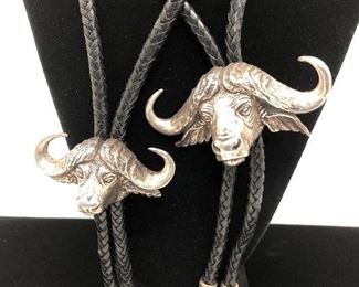South African cape buffalo bolos sculpted in sterling silver, signed, dated. Gents and ladies.