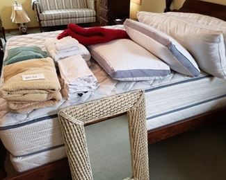 Four Pillows, Various Towels, and a Wicker Wall Mirror