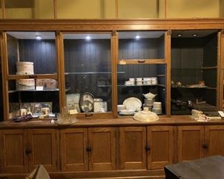 Antique Oak Store Display Cabinet-2 Sections, 20' 10" Long, 36" Depth, Height of Base 32", 93" Tall, 14 Doors.  There are 6 Glass Doors That Extend Upwards 52 Additional Inches From Cabinet (1 Missing), Lighted Case