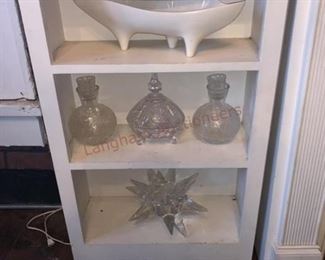 Lot 814 White Mirrored Fireplace Surround, White Shelves- Wooden white mirrored fireplace surround approx 7ft tall and 5ft wide; 8 candle holders; white dish; 4 pieces of clear glassware; two white wooden book shelves; sculpture; wall lamp with two lights; floral fireplace 