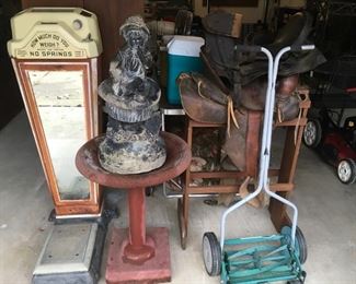 antique scale, iron bird feeder, leather saddle and antique lawn mower