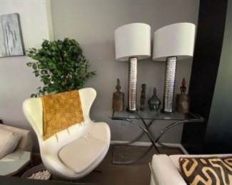 Glass Console, White Leather Accent Swivel Chair, Oversized Lamps, African Decor and Sculptures