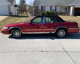 This 2000 Mercury Grand Marquis GS is a real beauty and showroom perfect.  One owner (retired woman) and always garaged.  Black soft top with sunroof, wire wheels with like new Michelin white walls . Low mileage.