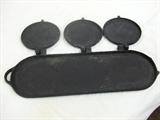 CAST IRON FLOP GRIDDLE IN OPEN POSITION.