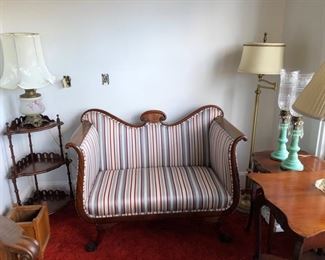 Parlor loveseat in excellent condition with assorted tables and lamps.