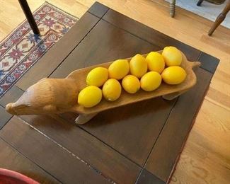 carved wooden dish of a pig with faux lemons