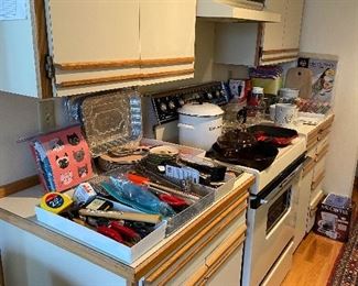 Kitchen items including cast iron skillet, Le Creuset grill pan, Le Creuset enamel stock pot and other kitchen accessories and tools