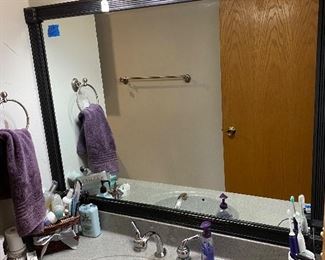 Close up of bathroom light fixture and vanity mirror.