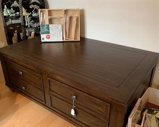 an Ethan Allen coffee table with ample storage drawers