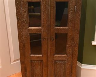 This diminutive cabinet is covered in tooled metal