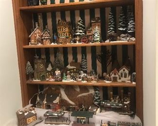 There are 4 bookshelves set up with the Christmas village scene