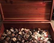 A wooden chest filled with vintage buttons