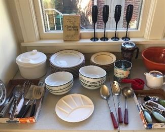 Assorted kitchen utensils (some with red Bakelite handles), tall black champagne flutes, assorted plates & bowls (orange bowl is gone)