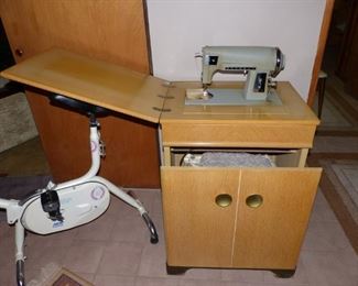 Sewing  machine in cabinet with hidden bench