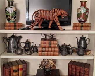 12" tall Asian cloisonne vases, vintage leather tiger,  collection of old silverplate teapots, leather bound books and antique English wooden boxes. 