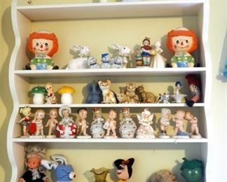 Ceramic Collectibles Including Raggedy Ann And Andy Planters, Handpainted Bells, Kitty Cats; And Wall Shelf, 34" x 28" x 6"
