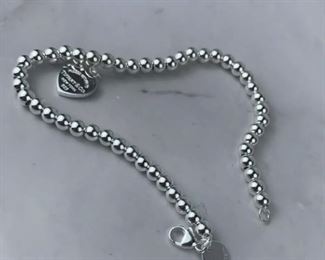 $75 Tiffany & Co. Return to Tiffany Heart Bead Bracelet is in excellent condition. Bracelet measures 7 inches in length. Features a sterling silver tag with Tiffany Pink enamal finish on a bead bracelet. Clasp is stamped 925 and back of heart charm is stamped ¡°Tiffany & Co. 925¡