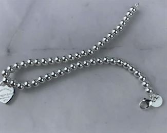 $75 Tiffany & Co. Return to Tiffany Heart Bead Bracelet is in excellent condition. Bracelet measures 7 inches in length. Features a sterling silver tag with Tiffany Pink enamal finish on a bead bracelet. Clasp is stamped 925 and back of heart charm is stamped ¡°Tiffany & Co. 925¡