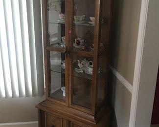 . . . a cute petite curio cabinet with a nice collection of cups and saucers.