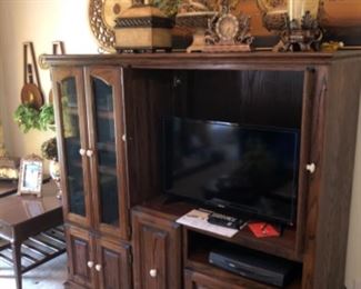 oak entertainment center with glass door and solid fold away doors.  This piece could be a curio, bar, bedroom chest, linen storage or tv cabinet.  Possibilities are only limited to your imagination. 