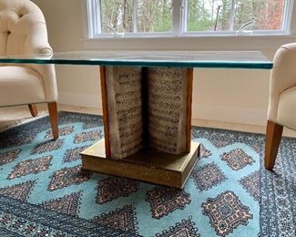 Glass top cocktail table with book pedestal
