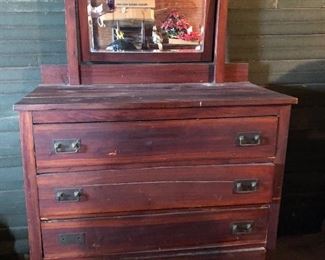 The four drawer cedar antique dresser with mirror is in excellent shape.