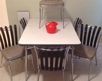 Kitchen: A RETRO dinette set with six chairs! How cool is that! The chrome table measures 35" x 49" and has one additional 9-3/4" table leaf. The retro red pitcher is glass.