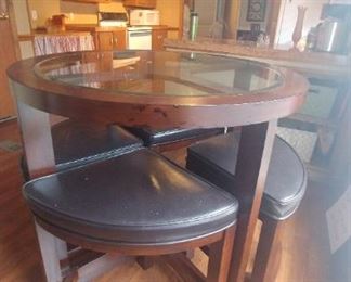 Kitchen dinette counter height table with four stools that nest under 36" round table.