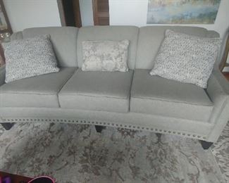 Grey sofa woth Nailheads and tight back cushions. Comes with three pillows. Custom sofa by England. Only 2 months old.