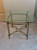 Glass Top Accent Table
This piece is a contemporary side table with a translucent glass top. The legs are metallic and connected with intersecting curved rods.