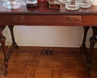 $195 - Item #12: Drop leaf "library" console table with beautiful tressle leg base. Some discoloration on drawer front and split in top. Otherwise no large scratches or wear. See next photos. 43.5" long,  66" with leaves up, 21.5" deep, 30" tall