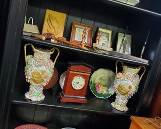 Top shelf, L to R: Oval floral oil painting, discounted price now $7.50; Art Deco Limoges pitcher with grapes, discounted price now $20
2nd shelf, L to R: Carved wooden praying hands plaque, discounted price now $12.50; copper trophy figures, discounted price now $10 each; gavels, discounted price now $3.50 small & $7.50 large; agate desk blotter, discounted price now $7.50; desk pen set, discounted price now $12.50
3rd shelf, L to R: Capodimonte jardiniere, discounted price now $97.50; Inlay clock (battery operated), discounted price now $20; Bavarian rose plate, discounted price now $15; Capodimonte jardiniere, discounted price now $97.50
Bottom shelf, L to R: Large round salmon Arcadia Ware platter, discounted price now $5; molded glass platter, discounted price now $3.50; molded glass platter, discounted price now $15; handled glass hors d’oeuvres dish, discounted price now $10; oval silver plate serving tray, discounted price now $7.50
***Please note: California sales tax wi