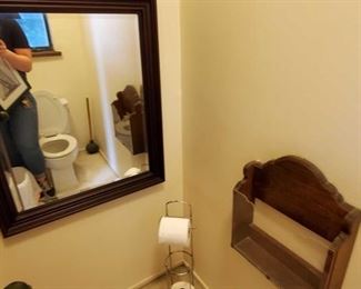 Framed mirror, toilet paper holder and magazine wall holder.
