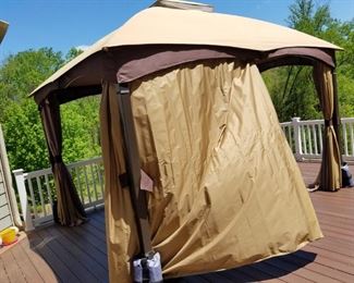 Hampton Bay outdoor canopy. 10' x 12', sides tie back/slide closed. Heavy construction w/ 4" metal poles w/ weights, hook inside for light fixture (not included), opening height is 7'. One year old!   $175.00