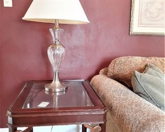 One of a pair of glass top mahogany vintage end tables with glass and silver tone contemporary lamp