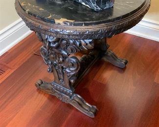 antique table with marble top, highly detailed carvings.