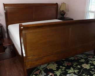 View 2: Cherry Kingsize Sleigh Bed. Safavieh 8’ Round Black Floral Area Rug shown in Foreground.