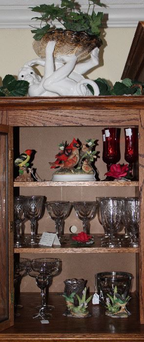 Exterior Cabinet of Entertainment Center showing contents of Miscellaneous Crystal Stemware , Bisque Flowers and Bird Figurines