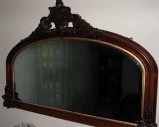 Gorgeous old mirror. It measures 48 inches wide and 32 inches tall with its grape motif crest. The mirror glass shows age with ripples and the gold rim of the frame shows wear. $145.00
