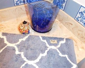 Blue glass waste basket $10.  Artsy night light $5.  Bathroom rug $4.