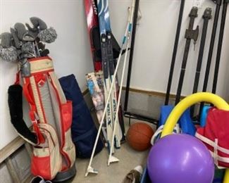 lot of skis, golf club and pool toys
