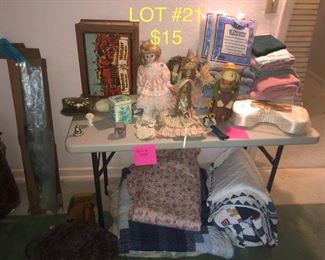 lot No. 21 Includes vintage straw characters, silk neck pillow, homemade quilts and comforters, space bags, collectibles, vintage German box, and towels