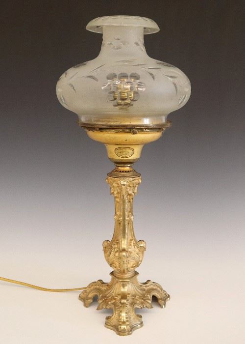 Lot 43: A mid 19th century Bronze Astral lamp by Cornelius & Co., Philadelphia.  Period frosted cut glass shade.  Some wear, converted for electricity.  20 1/4" high overall.