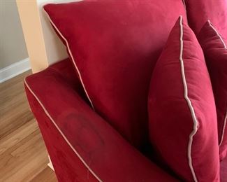 Now $185! ----$250- Super comfortable microsuede vibrant red sofa with four matching throw pillows. No manufacture name. No tears in fabric, but two staining issues- one on the back left arm and the middle cushion has a stain and has been turned upside down. (see all photos)  Has light tan piping. Measures approximately 103.5" long by 42" deep and 30.5" tall in the back and 27" tall in front. The cushions measure 30" deep 26.5" wide. 