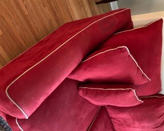Now $185! ----$250- Super comfortable microsuede vibrant red sofa with four matching throw pillows. No manufacture name. No tears in fabric, but two staining issues- one on the back left arm and the middle cushion has a stain and has been turned upside down. (see all photos)  Has light tan piping. Measures approximately 103.5" long by 42" deep and 30.5" tall in the back and 27" tall in front. The cushions measure 30" deep 26.5" wide. 