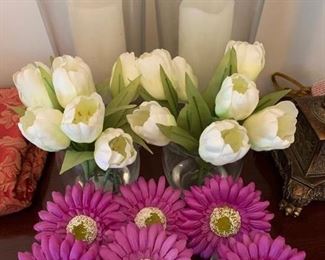 $10- Lot of home decor items; two hurricane holders about 12" tall, 2 faux Lilly's in vases and 6 mini vases with purple daisies. 