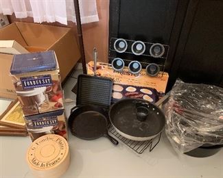 $50- lot of kitchen items; two fondue pots with fondue plates, one Lodge cast iron pan, a  large commercial frying pan, Presto griddle, All Clad griddle and a roaster 
