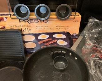 $50- lot of kitchen items; two fondue pots with fondue plates, one Lodge cast iron pan, a  large commercial frying pan, Presto griddle, All Clad griddle and a roaster