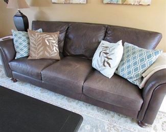 Faux leather sofa with (4) accent pillows. 92"w X 35"h X 37"d. PRICE: $395.00