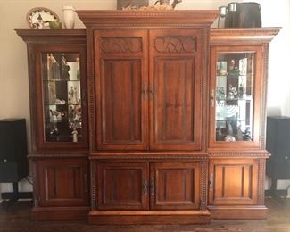 Entertainment Center, Solid wood, hand carved - 101”wide x 86” high at midpoint  x 24.5” front to back (deep). Lights inside of 
each tower - touch on via hinge, $975
